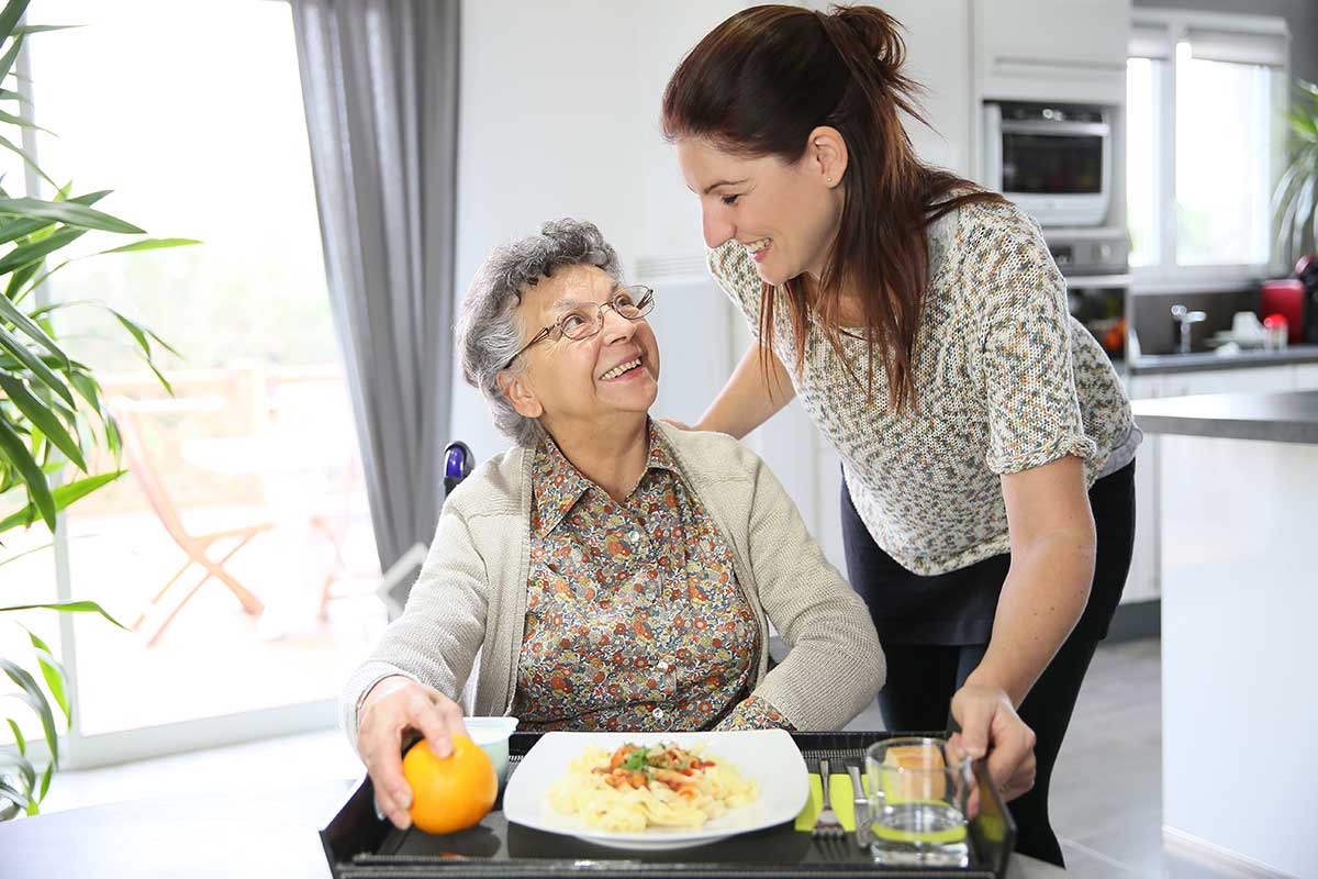 An ALTCS paid faily caregiver in Mesa AZ serving a home-cooked meal to an eldery family member